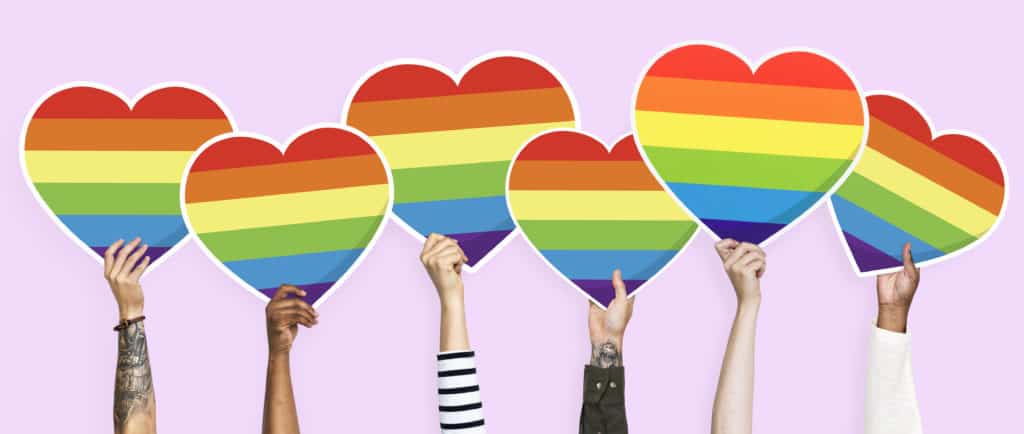 Hands holding a lgbt rainbow heart graphic